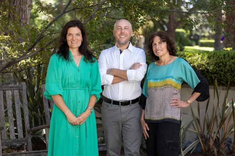 Heather Thomason, Kurt Gonska, and Sue Himmelrich standing together in a garden.