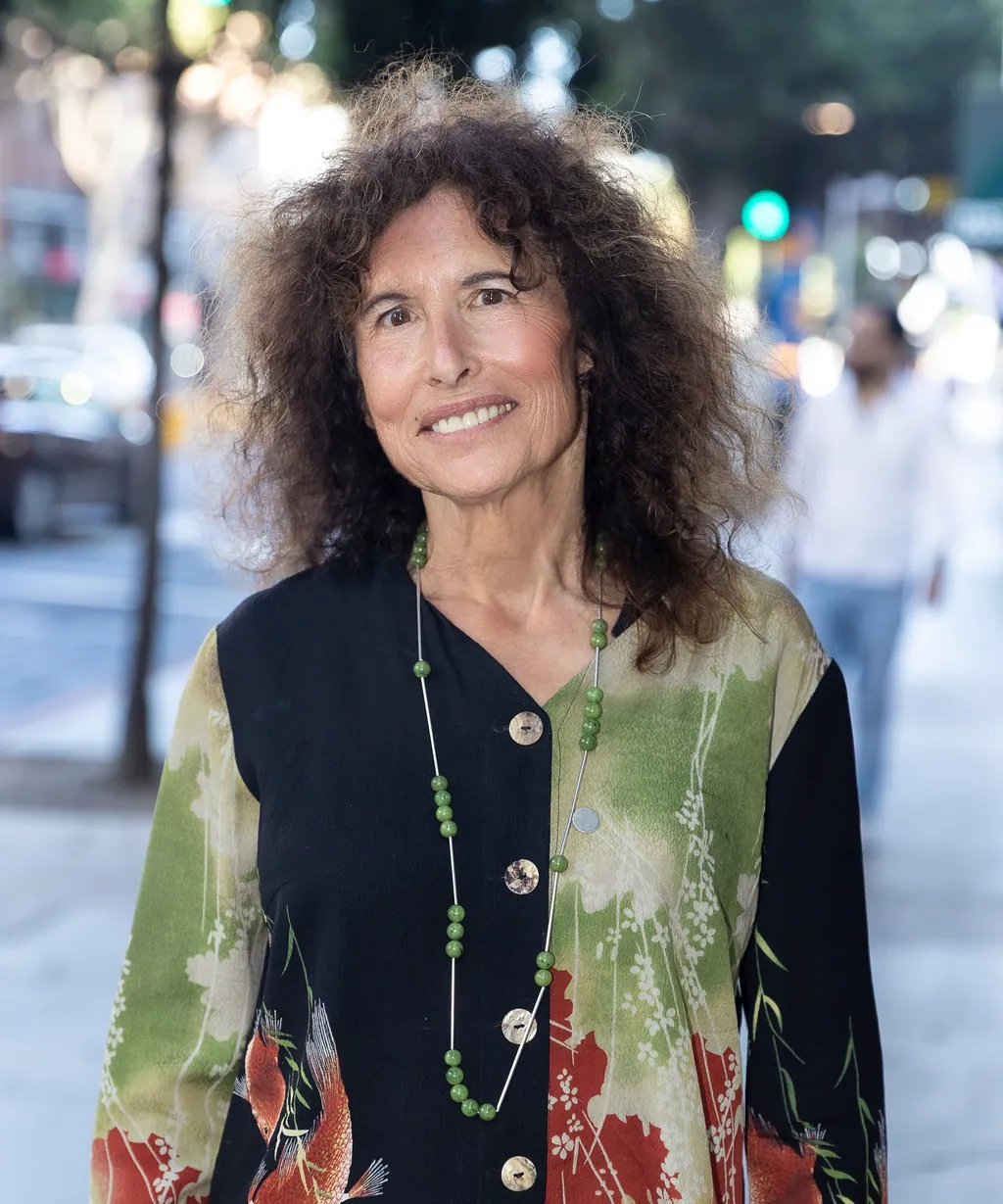 Sue Himmelrich smiling on a tree-lined Santa Monica sidewalk.
