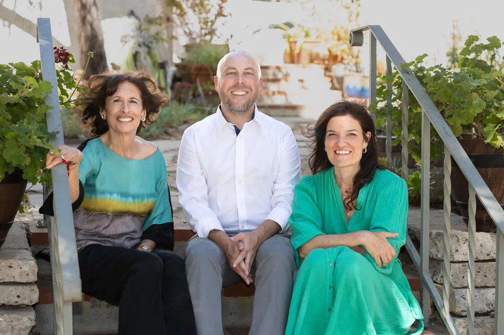 Sue Himmelrich, Kurt Gonska, and Heather Thomason sitting together on garden steps.