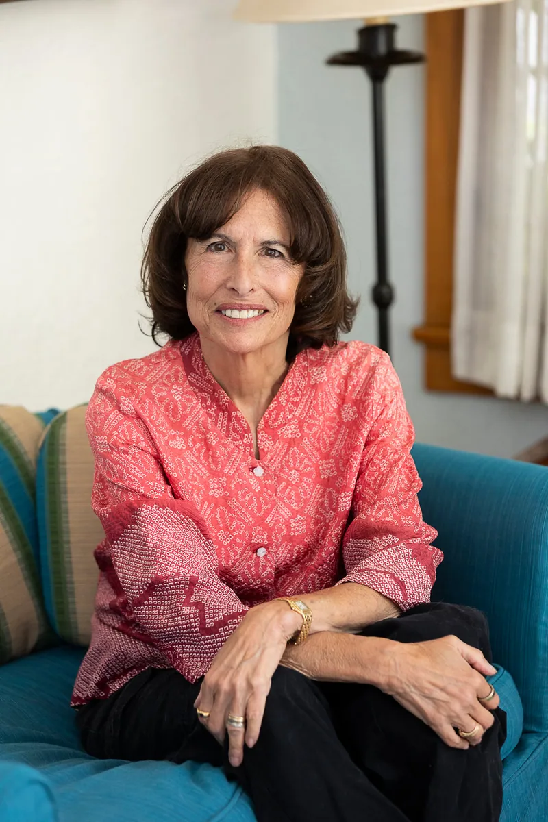 Sue Himmelrich seated on a blue sofa at home.